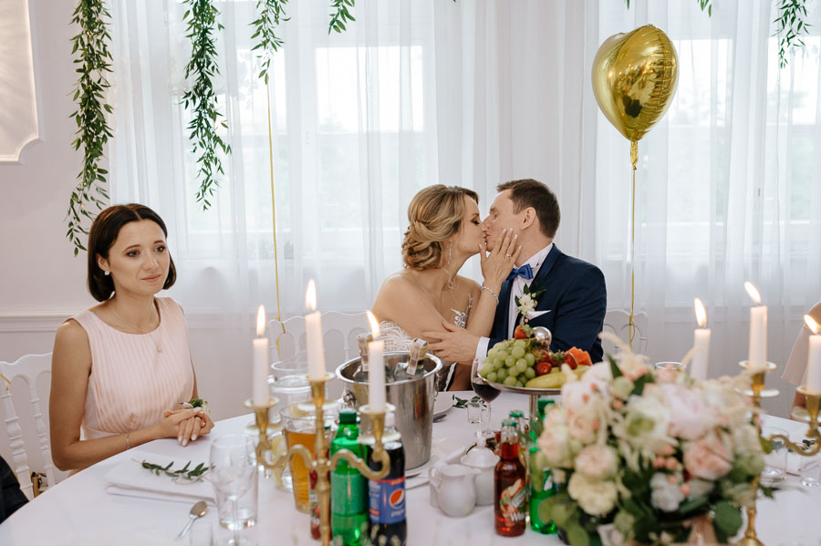 Fotograf ślubny Kraków - Sfotografowani Marcin Pluta Buziak przy stoliku, Fotografia weselna, Piękne kadry ślubne