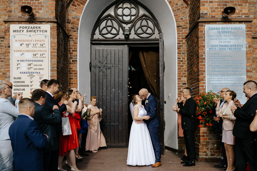 Pocałunek po wyjściu z kościoła, Fotografia weselna, Piękne kadry ślubne